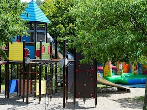 A playground with climbing structures, slides, and a covered play area. - Mobile home with air conditioning - 4 guests (Vans)