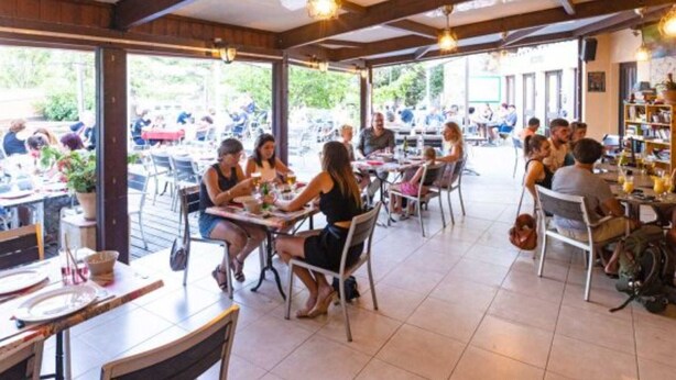 An outdoor dining area with multiple tables and chairs, large windows, and a covered roof structure. - Mobile home AC, pets welcome - 4 guests (Lézignan-Corbières)