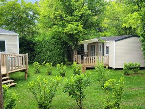 A campsite with two cabins, wooden decks, and a well-maintained lawn. - Mobil-home - pets welcome - 6 guests (La Douze)