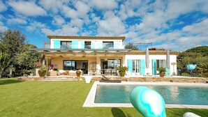 Ein modernes Haus mit Swimmingpool, einem gepflegten Rasen und einer Terrassenfläche.
