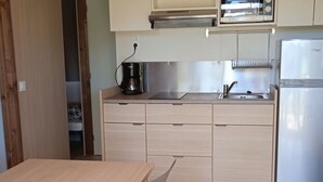 A compact kitchen with a sink, stove, and a refrigerator.