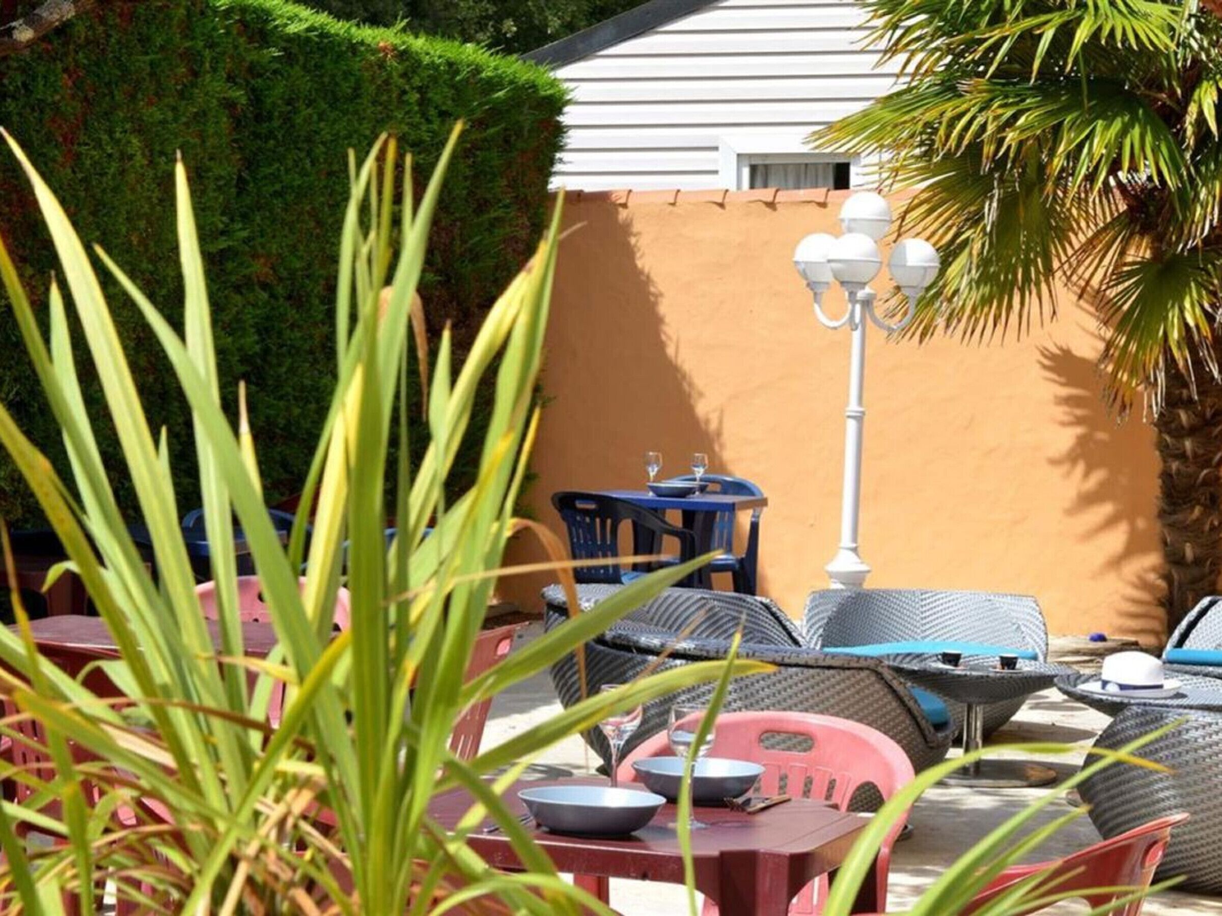 An outdoor patio with wicker furniture, a table with a bowl, and a lamp post.