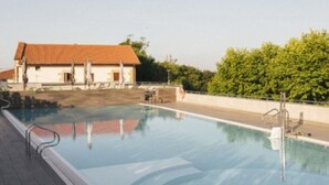 En swimmingpool med fri utsikt över en byggnad med ett rött tak i bakgrunden.