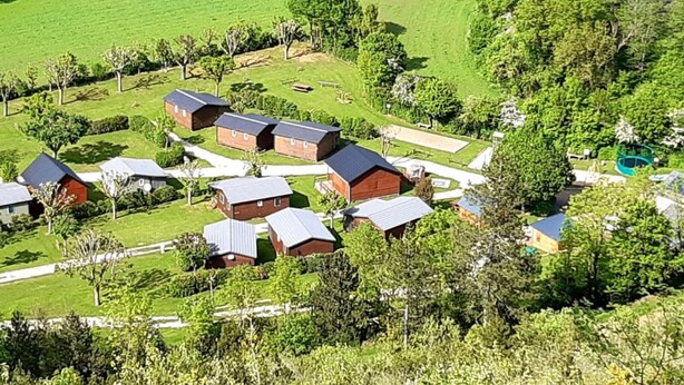 A residential area with multiple houses, a playground, and a large green field.