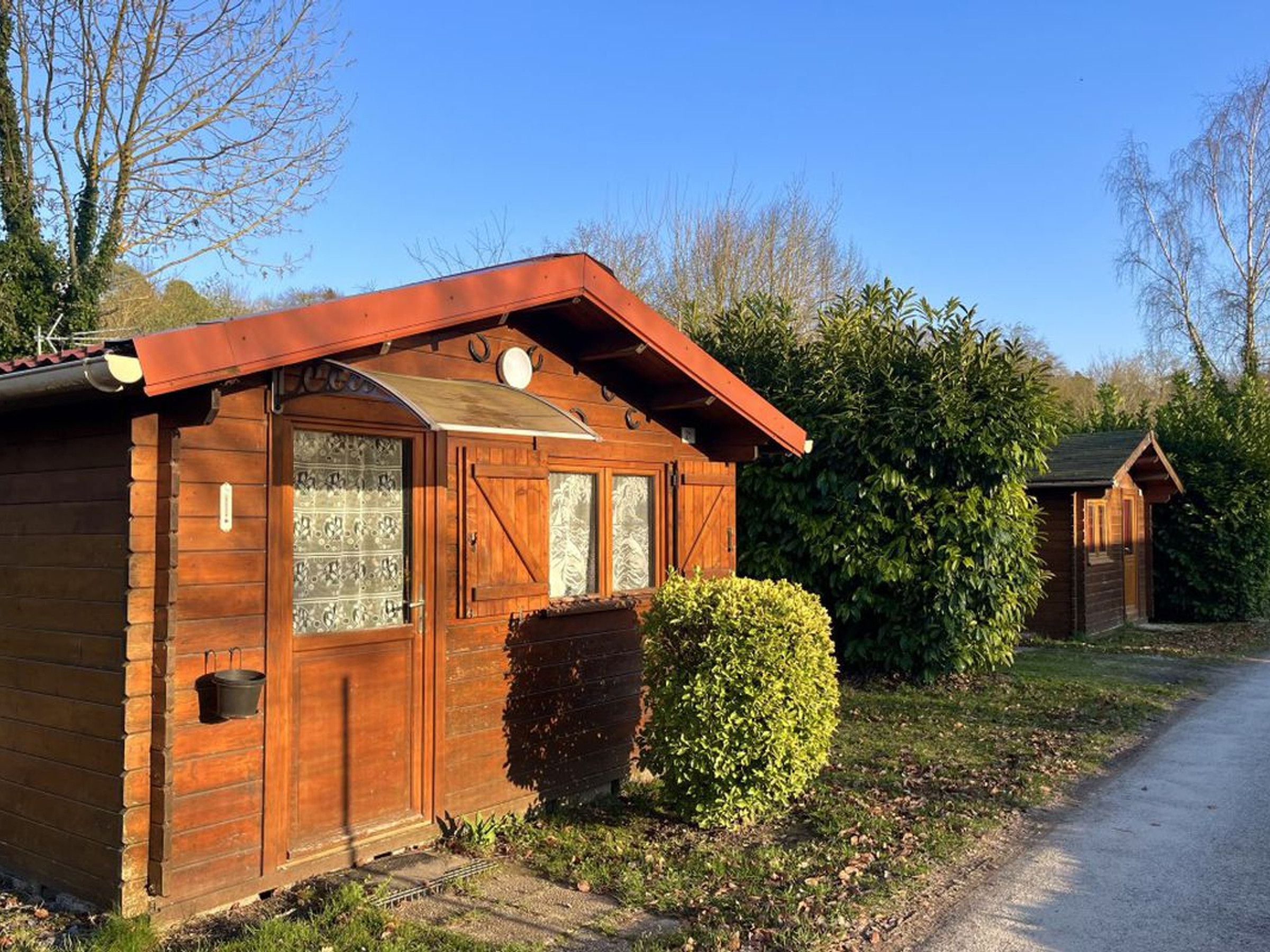 A wooden cabin with a sloped roof, a front door, and a small window.