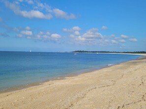 A beach with clear water, a sandy shore, and a distant shoreline with trees. - Cozy mobile home with TV - 4 guests (Sarzeau)