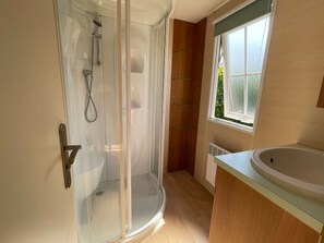 A bathroom with a glass shower enclosure, a sink, and a window with a view. - Mobile home for 4 guests - Saint-Lunaire (Saint-Lunaire)