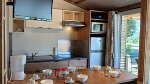 A compact kitchen with a microwave, stove, and refrigerator.