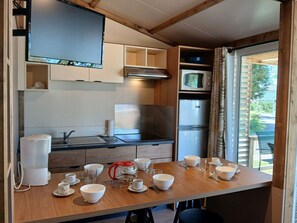 Une cuisine compacte équipée d’un four à micro-ondes, d’une cuisinière et d’un réfrigérateur.