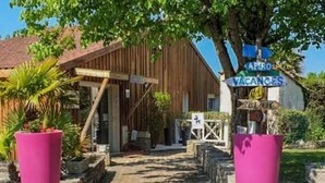 Ein Weg, der zu einem Holzhaus mit einem Schild führt, auf dem 'VACANCES' steht.
