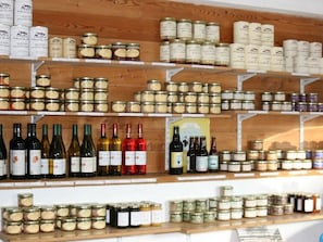 Een winkel met wijnflessen en blikvoer op de planken.
