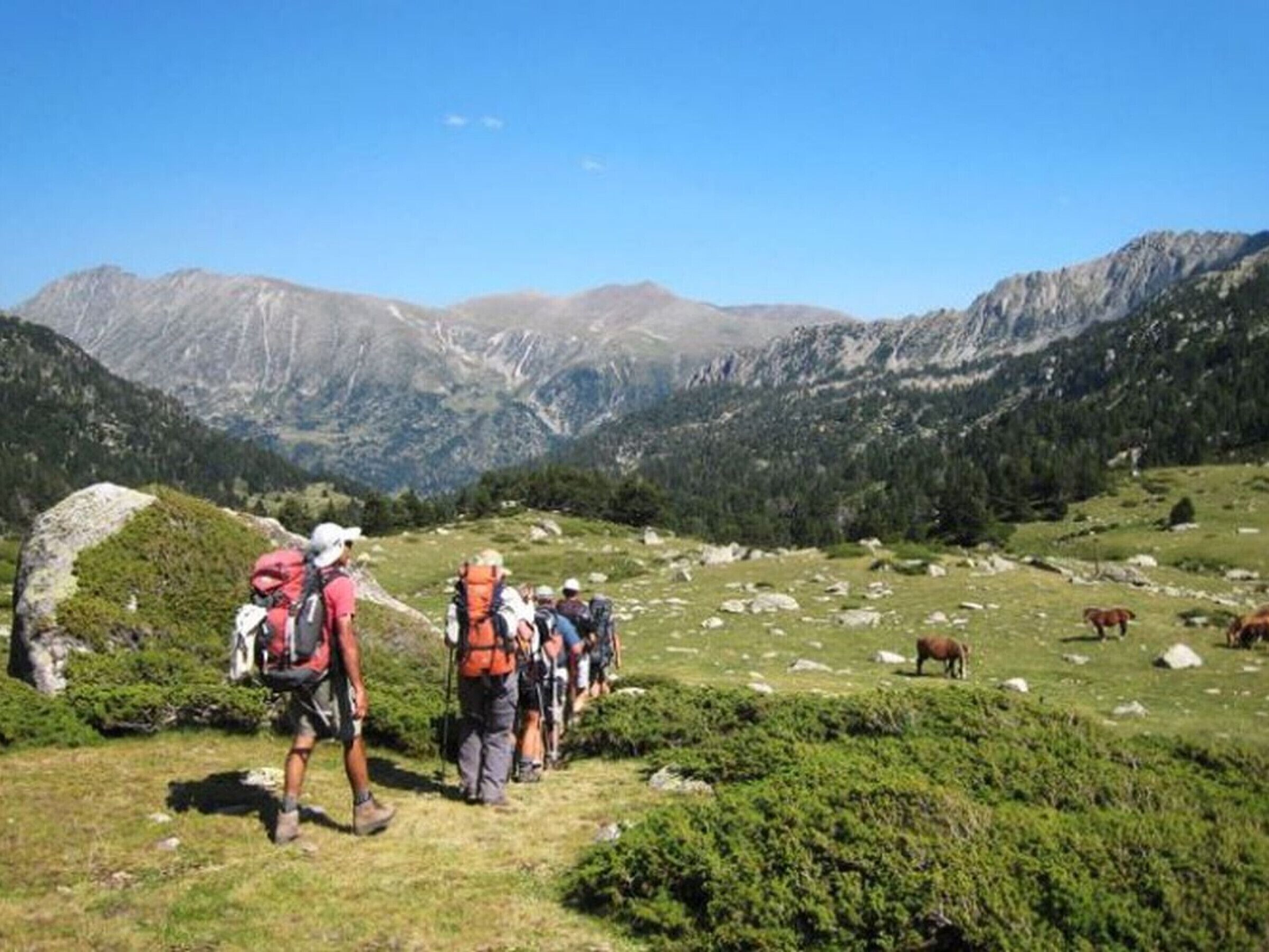 A mountainous landscape with hikers on a trail.