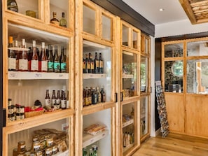 A wooden cabinet with glass doors containing various bottles and jars.