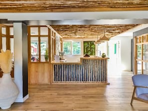 A reception area with a wooden reception desk, a large window, and a blue chair.