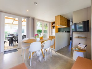 Una cocina moderna con comedor, televisor y vistas al exterior.