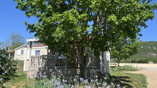 A house with a porch, surrounded by a garden with purple flowers. - Chalet pets welcome - 5 guests (Saint-Georges-de-Luzençon)