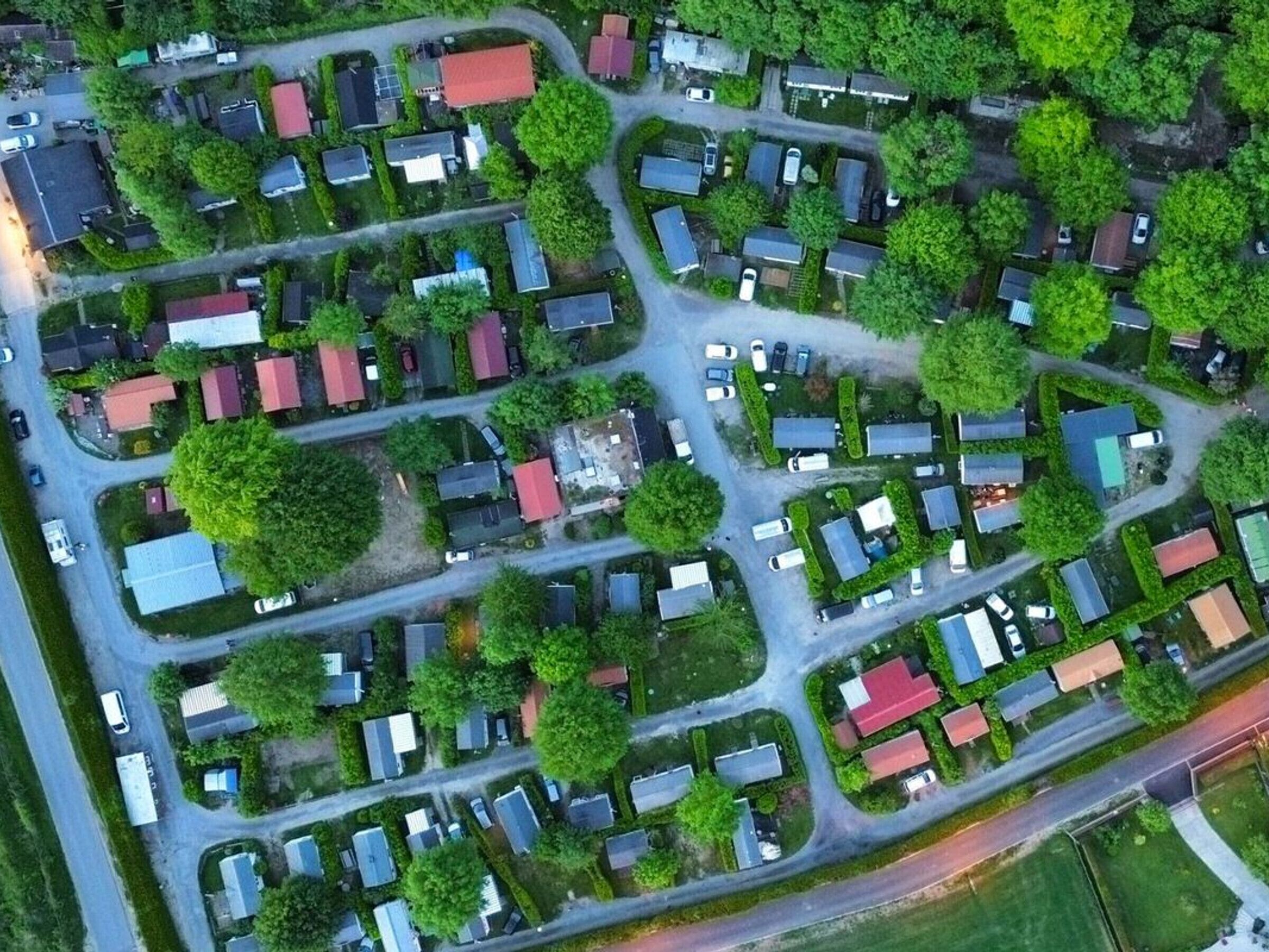 Une vue aérienne d’un quartier résidentiel avec de nombreuses maisons, des rues et des espaces verts.