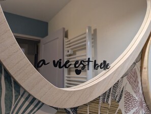 Un hamac orné d’une phrase en français, une porte blanche et un mur à motifs.