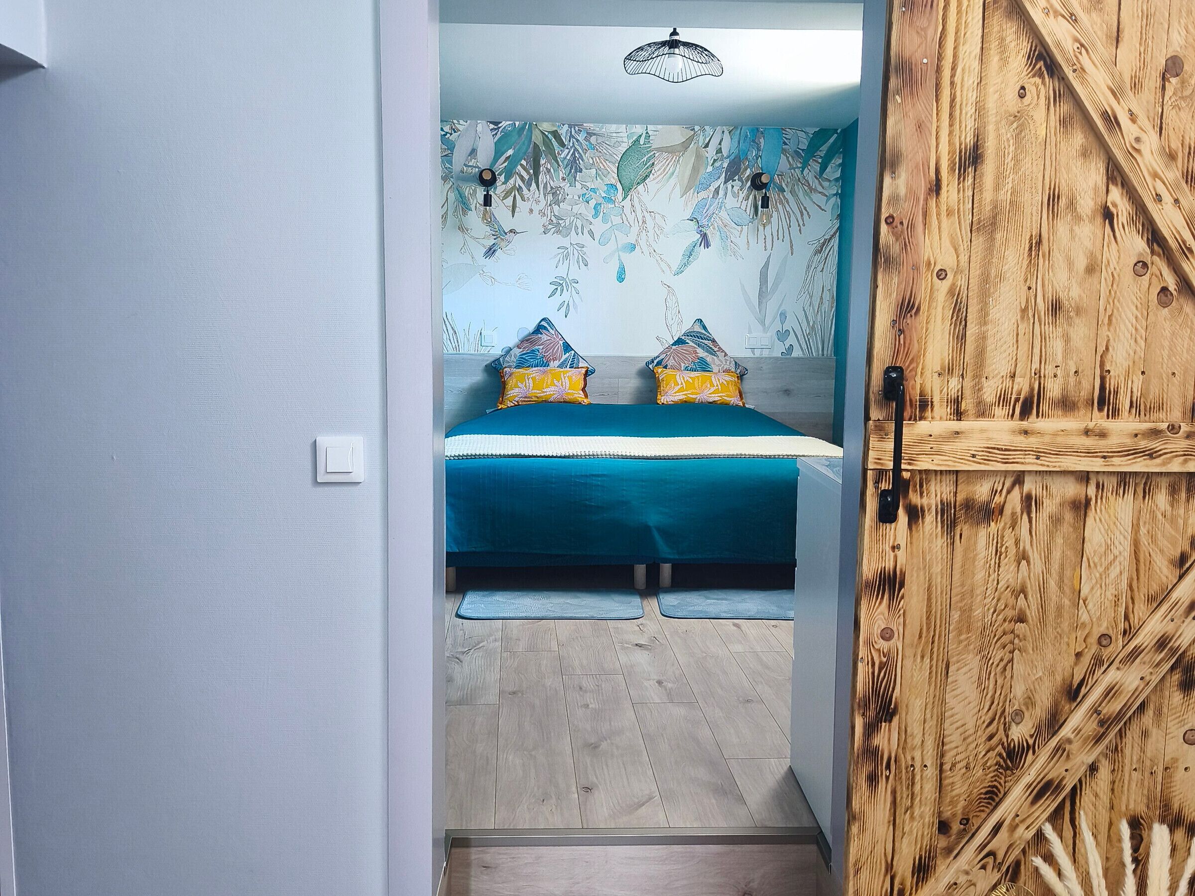 Une chambre à coucher avec un lit, des oreillers et une porte en bois.