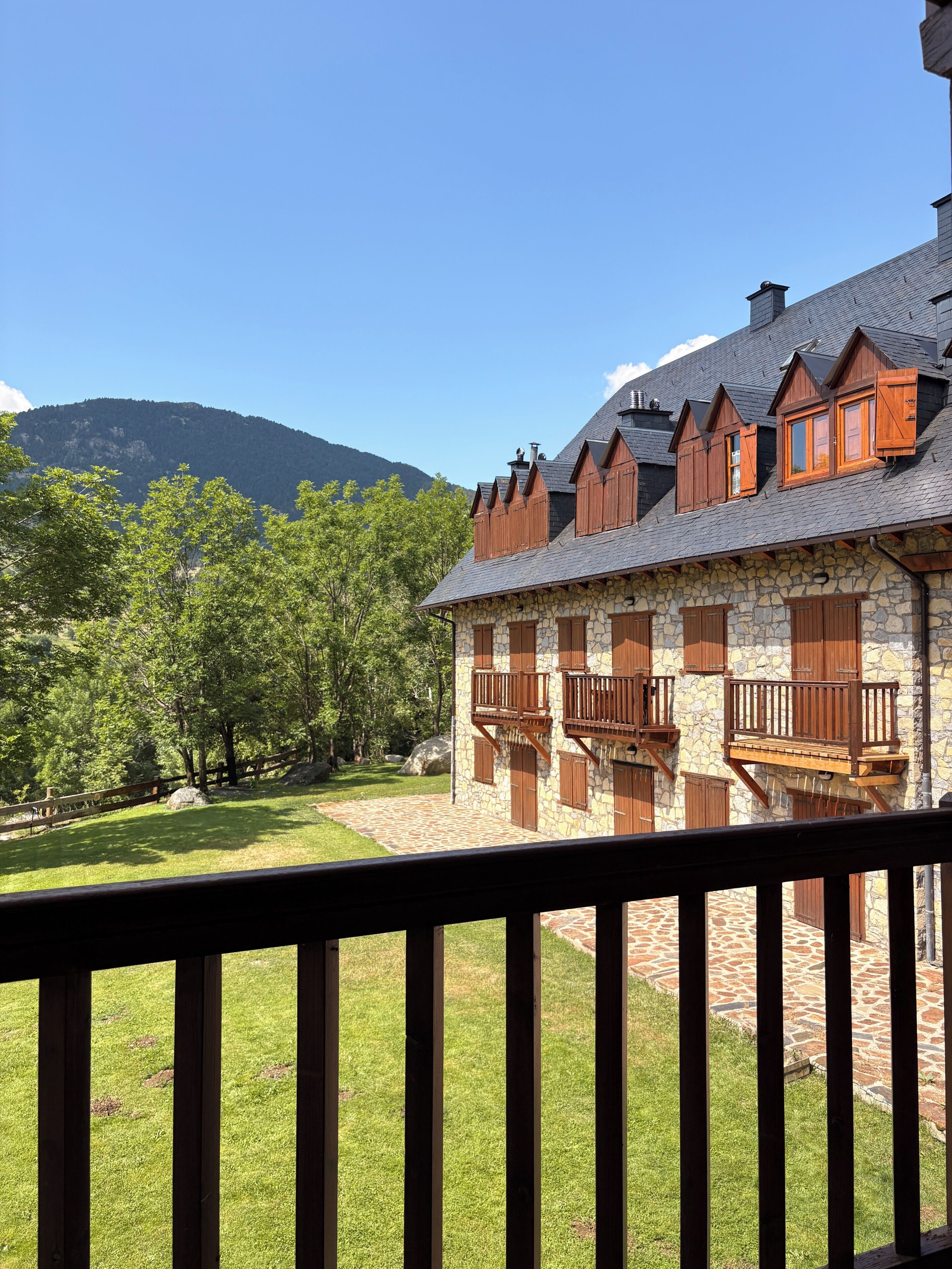 A stone building with wooden balconies and a stone patio.