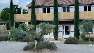 Un bâtiment à deux étages, doté d’un toit en tuiles, d’une entrée principale et d’une allée gravillonnée.