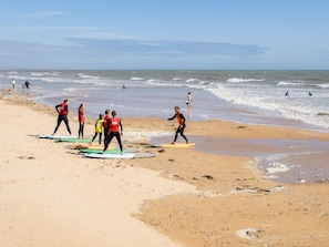 Una playa con gente surfeando y un socorrista en el agua.
