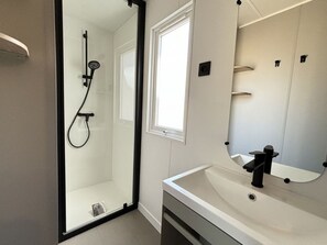 A modern bathroom with a glass-enclosed shower, a white sink, and a large mirror. - Mobile home with AC, pets allowed - 4 guests (Soustons)