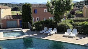 A rectangular pool with clear water, surrounded by a wooden deck and white lounge chairs. - 2-bedroom house with garden and sea view in La Croix-Valmer (La Croix-Valmer)