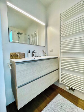 A modern bathroom with a large mirror, a white vanity, and a towel rack. - Sparkling Antwerp Penthouse Near Hub (Antwerp)