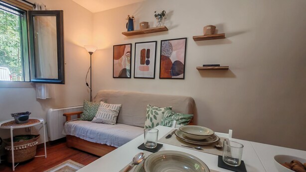 A living room with a sofa, a dining table set with plates, a bowl of nuts, and a floor lamp. - Your comfortable shelter with pool - Herbasabina 2 (Pla de l'Ermita)