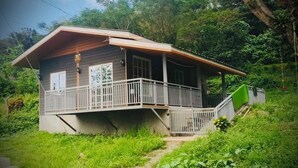 Una casa con porche, escaleras y jardín.