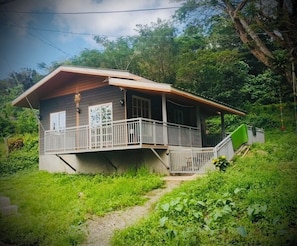 A house with a porch, a staircase, and a garden.