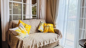 Un espacio de sala acogedor con un sofá, una ventana y vistas al exterior.