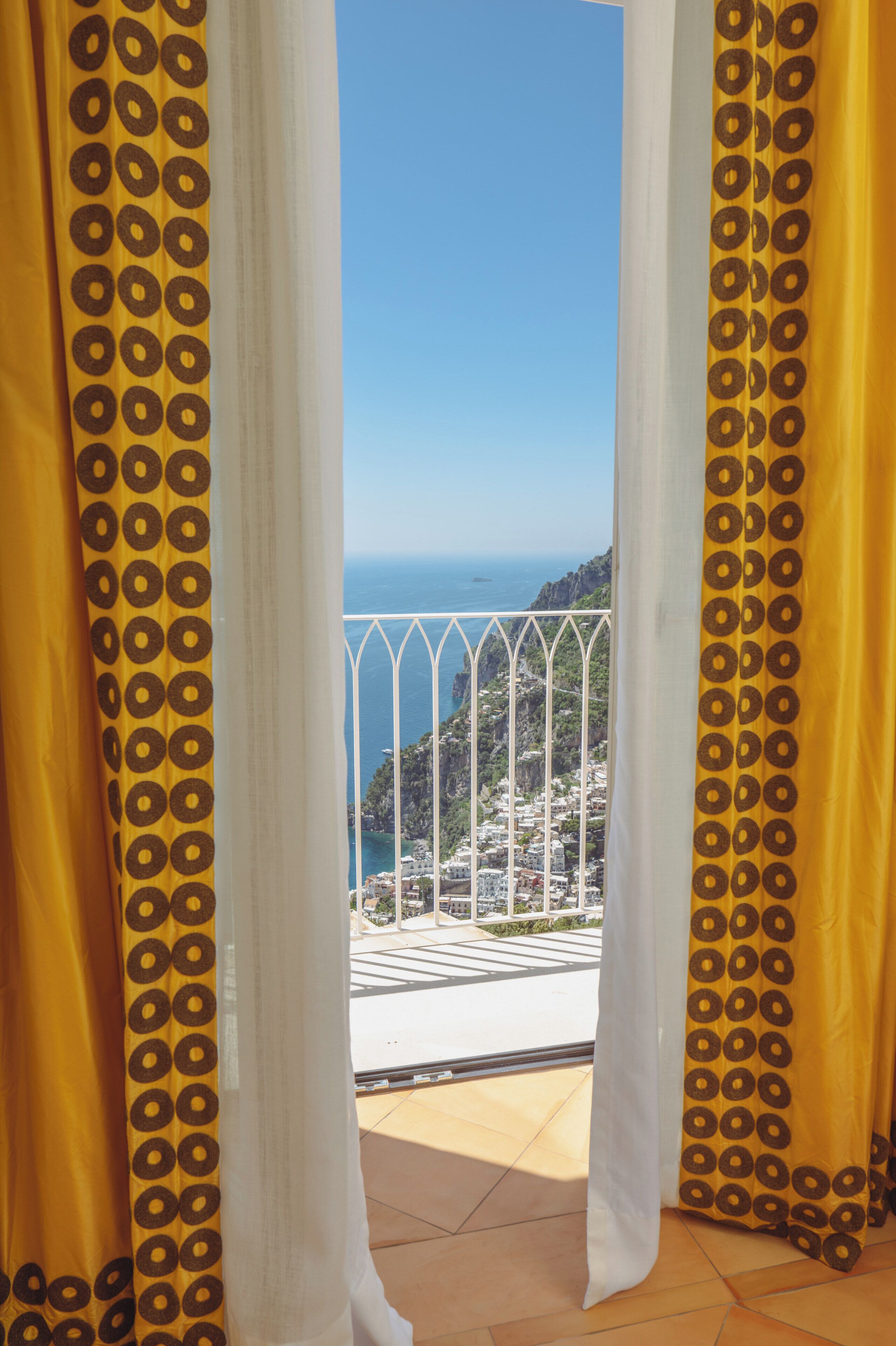 Un balcón con vista al mar y un paisaje montañoso.
