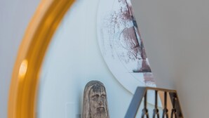 Una escalera con barandilla de metal y una escultura de madera en la pared.
