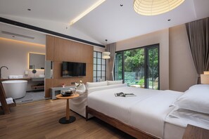 A modern hotel room with a large bed, a flat-screen TV, a bathtub, and a large window offering a view of greenery. - Dyed Mount Boutique Hotel (Guilin)
