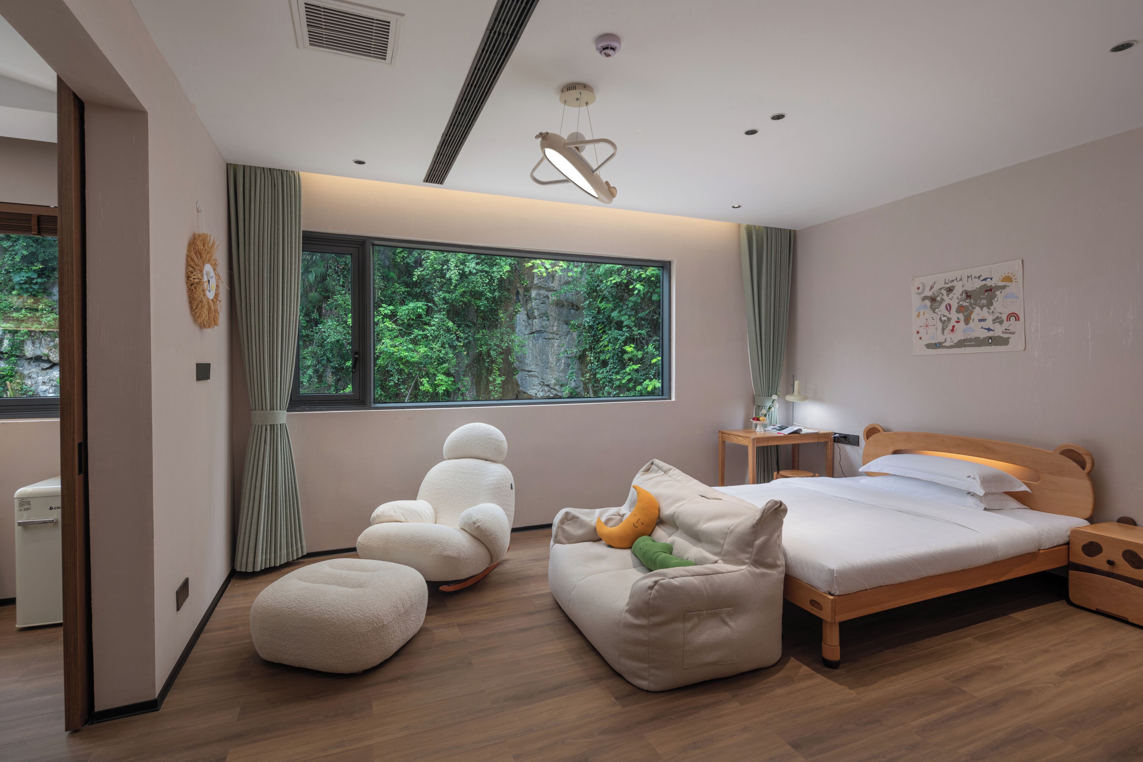 A modern bedroom with a large window, a bed, a desk, and a chair.