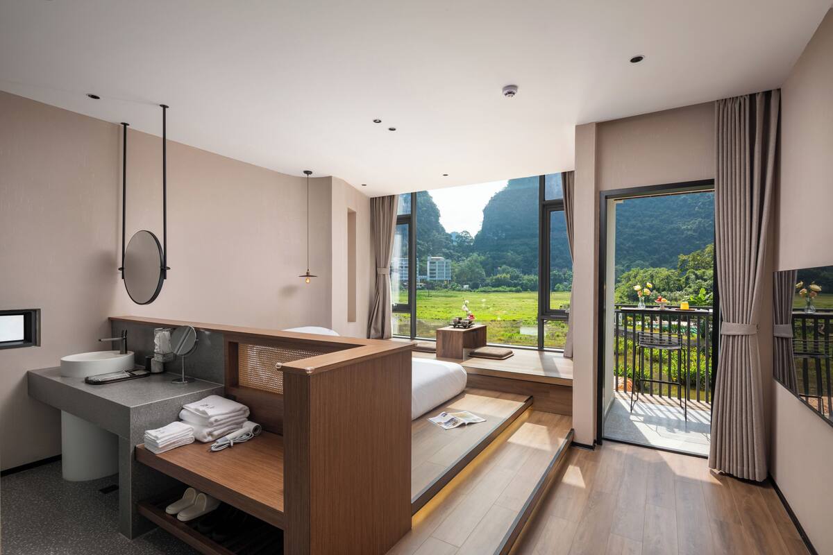 Een moderne badkamer met een wastafel, spiegel en houten bankje.
