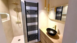 A modern bathroom with a shower, a sink, and a mirror. - Luxury Apartment With sea View (Middelkerke)