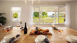 A dining table set with wine glasses, a bottle, and a charcuterie board. - The Meadow Yarra Valley Spa Sauna (Yarra Glen)