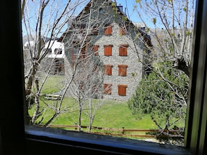 Un edificio de piedra con varias ventanas y un patio cubierto de césped.