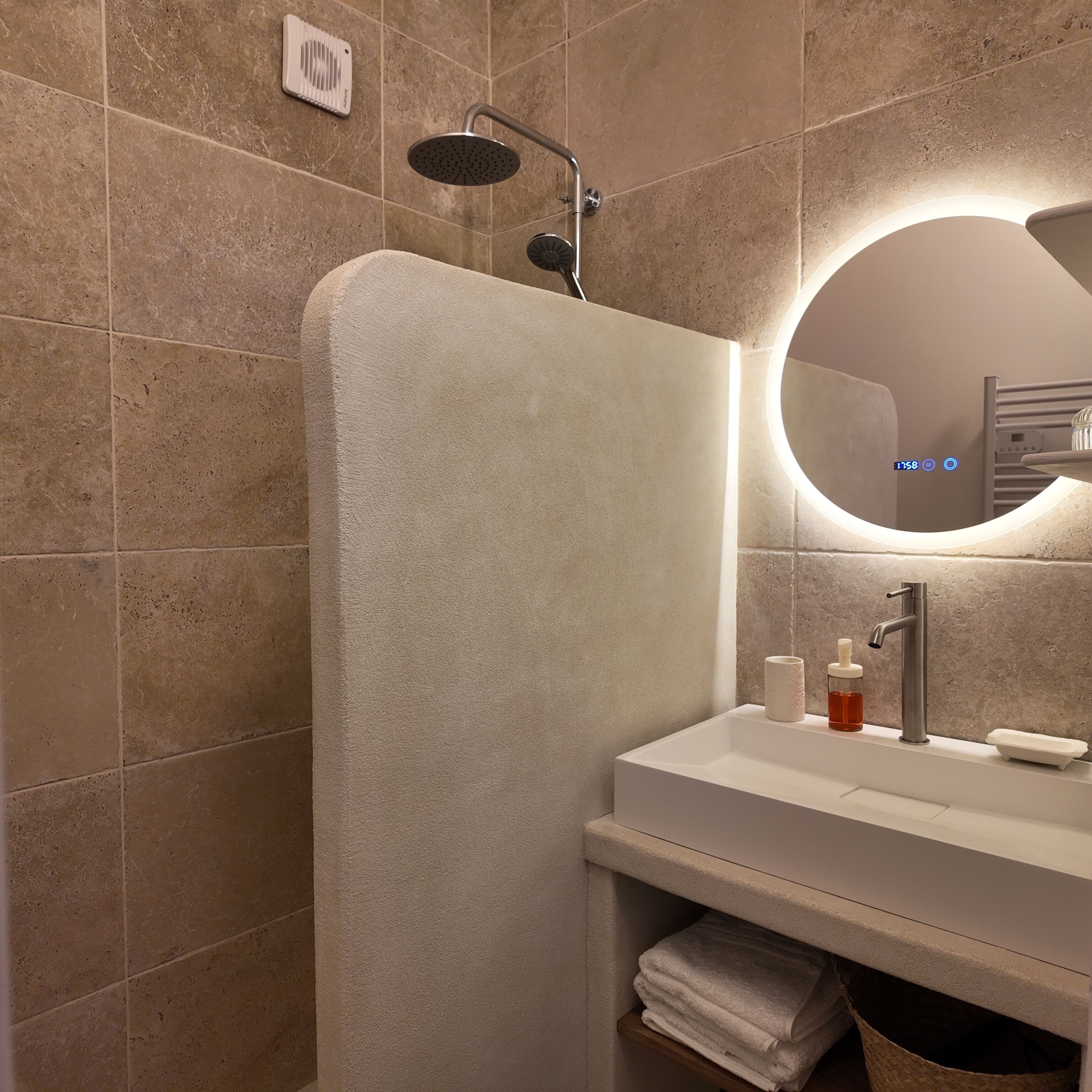 Un baño moderno con ducha, lavamanos y espejo.