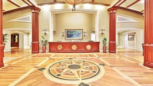 A spacious lobby with a central reception desk, a large globe chandelier, and a patterned floor design. - Breathtaking Views Emerald Grande 3BR/2BA 904E (Destin)