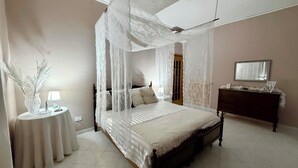 A bedroom with a four-poster bed, a bedside table with a lamp, a dresser, and a mirror on the wall. - Susanna's House, a carefree stay a stone's throw from downtown (Nocera Inferiore)