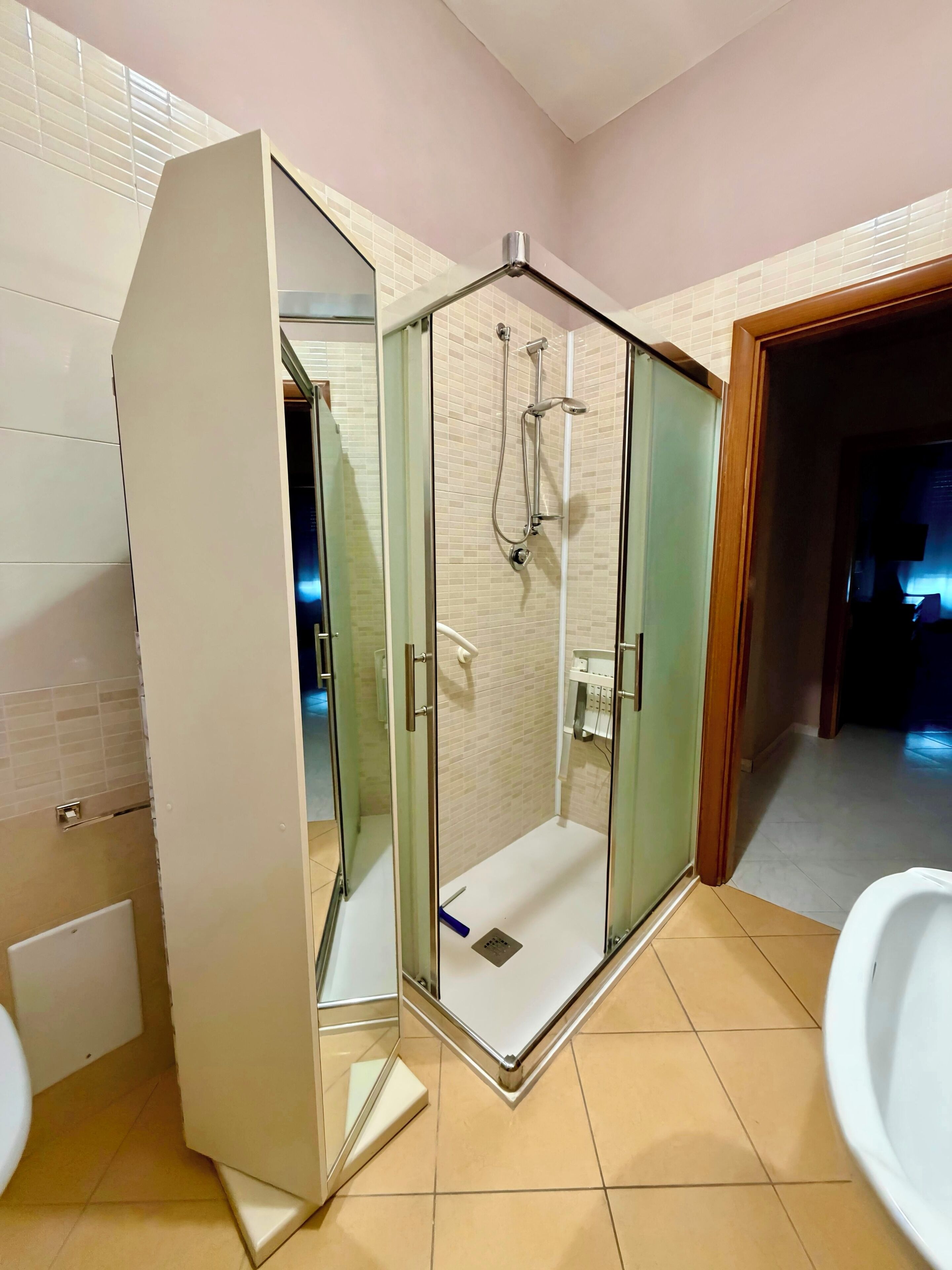 Un bagno moderno con doccia vetrata, un water e un lavandino.