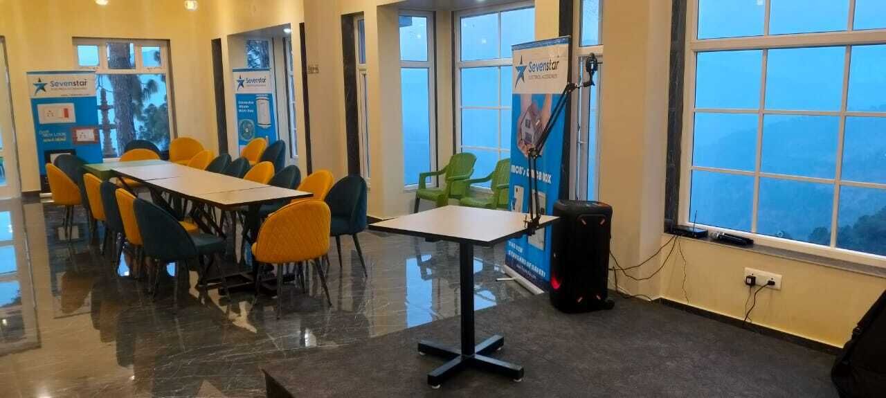 Una sala de conferències amb una taula llarga i cadires, un projector i una finestra amb vistes.