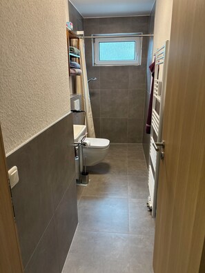 Regadera, secadora de cabello, papel de baño 