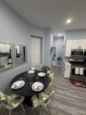 A modern kitchen with white cabinets, a stainless steel oven, and a microwave. - Modern Unit minutes away from MetLife Stadium (Newark)
