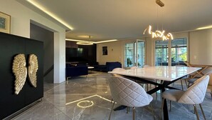Una zona de menjador moderna amb un paviment de marbre, una taula de dinar gran i cadires contemporànies.