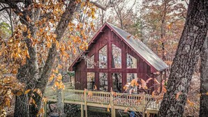 A rustic cabin with a metal roof, large windows, and a wooden deck. - Eremos – A Peaceful Browside Escape with Unforgettable Views (Mentone)
